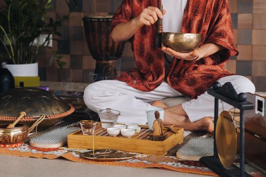 Tibetan singing bowl in the hands of a man during a tea ceremony.