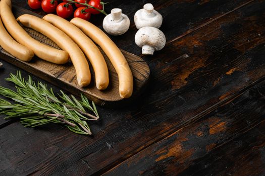 Classic boiled meat sausages set, on old dark wooden table background, with copy space for text