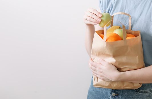 Delivery healthy food background. Vegan vegetarian food in paper bag vegetables and fruits on white, copy space, banner.Grocery shopping food supermarket and clean vegan eating concept.