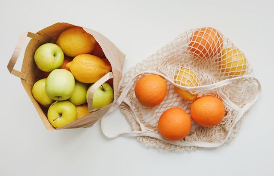 Lemons in reusable bag. Zero waste concept with string bag, mesh bag, grosery bag with fruits on white background, flat lay, top view, copy space.