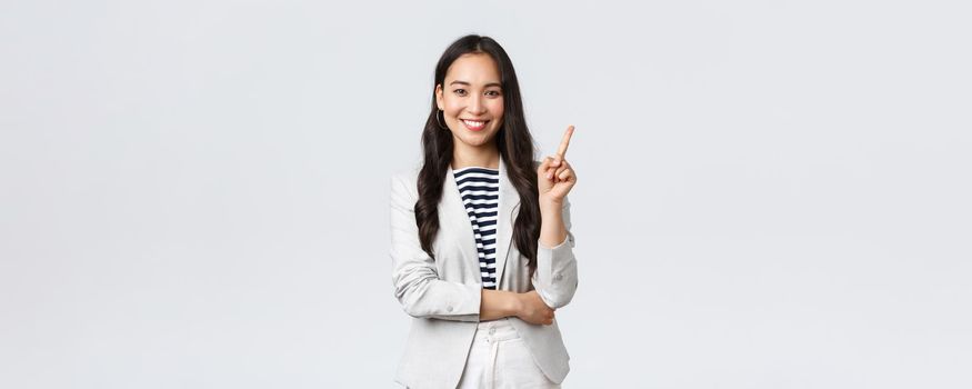 Business, finance and employment, female successful entrepreneurs concept. Successful female businesswoman, asian real estate broker pointing finger, showing number one and smiling.