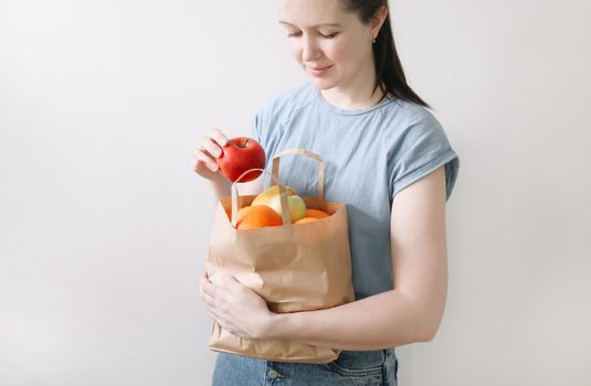 Delivery healthy food background. Vegan vegetarian food in paper bag vegetables and fruits on white, copy space, banner.Grocery shopping food supermarket and clean vegan eating concept.