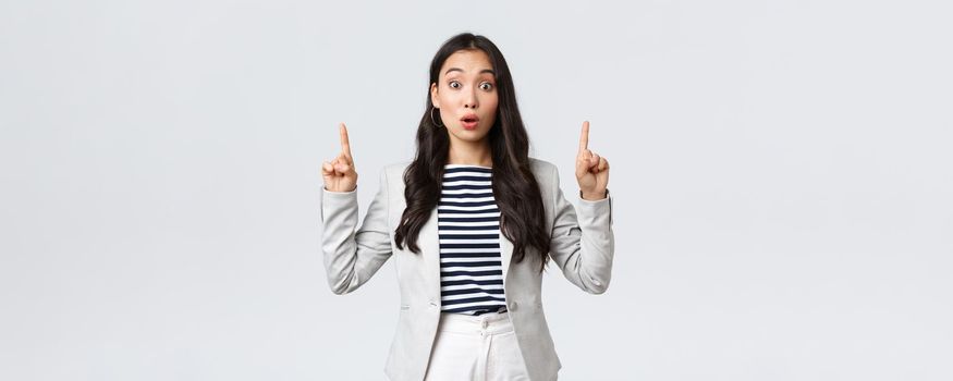 Business, finance and employment, female successful entrepreneurs concept. Real estate worker in white suit inform people about special offer, pointing fingers up saying wow.