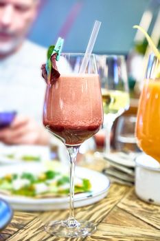 Cocktail or smoothie in a wine glass is on the table