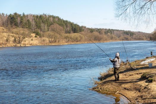 A fisherman fishing with a rod on the shore of river Neman. Grodno, Belarus