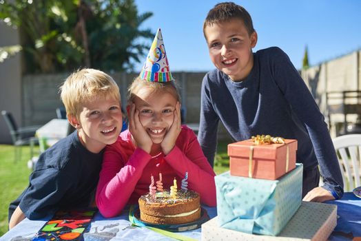 Portrait of a group of young children enjoying an outdoor birthday party.