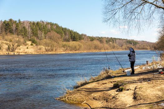 A fisherman fishing with a rod on the shore of river Neman. Grodno, Belarus