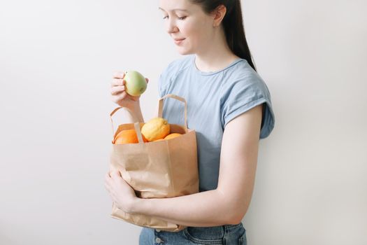 Delivery healthy food background. Vegan vegetarian food in paper bag vegetables and fruits on white, copy space, banner.Grocery shopping food supermarket and clean vegan eating concept.