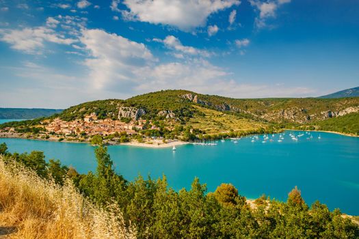 The city on the bank of the artificial lake in France, Provence, lake Saint Cross, gorge Verdone, azure water of the lake and slopes of mountains on a background, small boats, vacations place. High quality photo