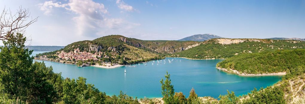 The city on the bank of the artificial lake in France, Provence, lake Saint Cross, gorge Verdone, azure water of the lake and slopes of mountains on a background, small boats, vacations place. High quality photo