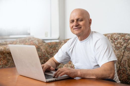 Old kind grandfather trying to use alone the internet