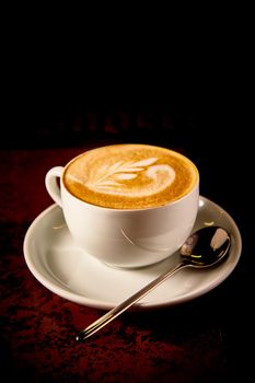 A Cup of cappuccino coffee on a dark background
