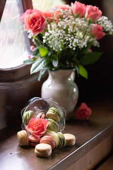 flowers and sweets, pink roses, multi-colored macaroons, still life on the windowsill, congratulations on valentine's day or birthday, high quality photo