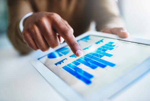 Closeup shot of an unidentifiable businessman using a digital tablet in an office.