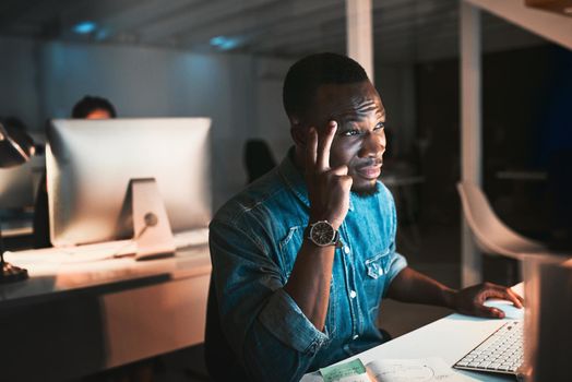 High angle shot of a young male designer looking stressed while working on his computer in the office.