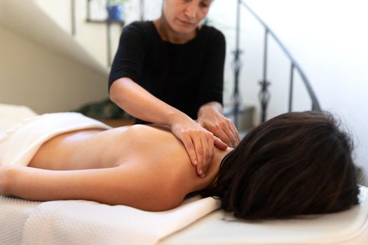 Young caucasian woman receiving therapeutic back massage. Bodycare and wellness concept.