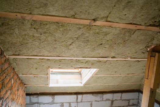 Window mounted in a pitched roof insulated with mineral wool