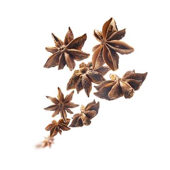 Anise stars levitate on a white background.