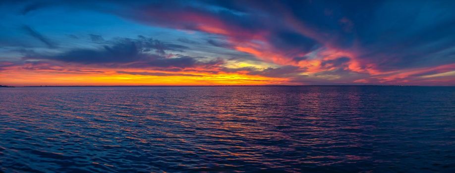 Beautiful sunset over the water surface on a summer evening