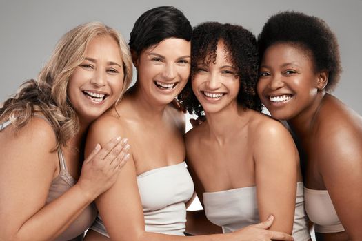 Shot of a diverse group of women standing and hugging each other in the studio.