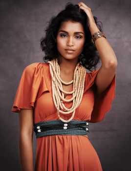 Studio portrait of a beautiful young fashion model posing against a gray background.