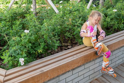 Little girl learns to roller skate outdoors