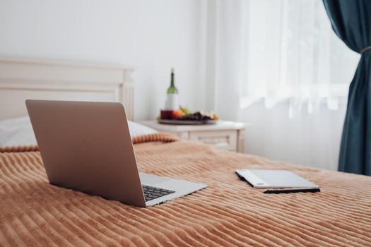 Laptop and Digital Tablet Laying on Bed in Hotel Room, Freelance Concept, Workplace for Designer Freelancer or Illustrator Artist