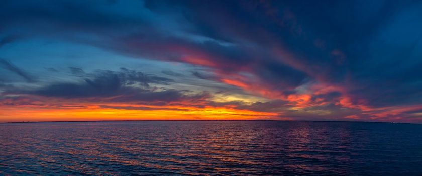 Beautiful sunset over the water surface on a summer evening