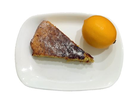 a piece of lemon biscuit and a fresh lemon on a plate, isolated.