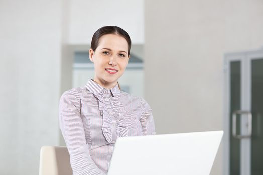 Attractive young woman works with a laptop