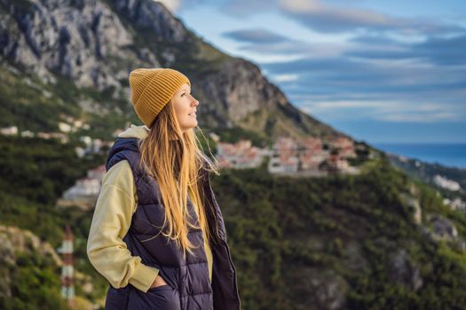 Woman in the mountains of Montenegro in warm clothes. Travel to Montenegro in spring, autumn, winter.