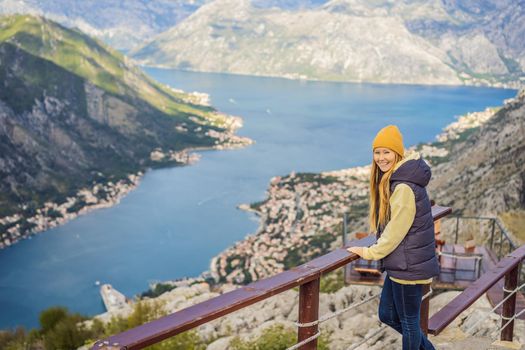 Woman tourist enjoys the view of Kotor. Montenegro. Bay of Kotor, Gulf of Kotor, Boka Kotorska and walled old city. Travel to Montenegro conceptFortifications of Kotor is on UNESCO World Heritage List since 1979.