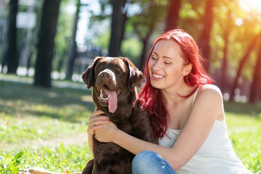 Woman in the park hugs a dog. Spend time with pets