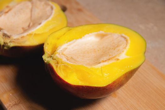 Close-up shallow depth of field cutaway mango kent on a cutting board. Mango home cooking.