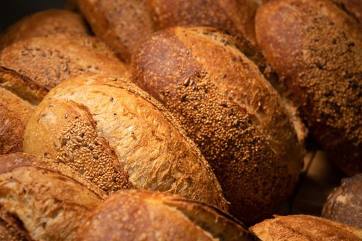 Sourdough bread close-up. Freshly baked round bread with golden crust on bakery shelves. The context of a German bakery with a rustic assortment of bread