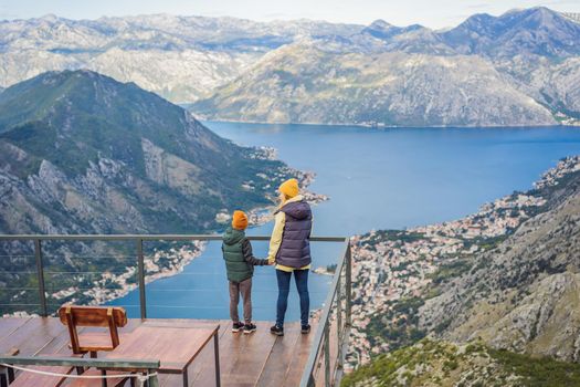 Mother and son travellers enjoys the view of Kotor. Montenegro. Bay of Kotor, Gulf of Kotor, Boka Kotorska and walled old city. Travel with kids to Montenegro concept. Fortifications of Kotor is on UNESCO World Heritage List since 1979.