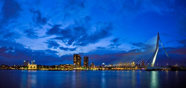 Panorama of Erasmus Bridge (Erasmusbrug) and Rotterdam skyline illuminated at night. Rotterdam, Netherlands