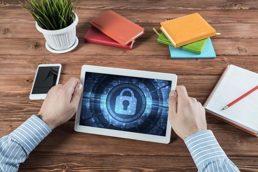 close-up, male hands with tablet. Businessman working at the table in office. computer security concept