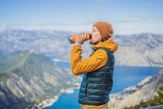 Man tourist enjoys the view of Kotor. Montenegro. Bay of Kotor, Gulf of Kotor, Boka Kotorska and walled old city. Travel to Montenegro concept. Fortifications of Kotor is on UNESCO World Heritage List since 1979.