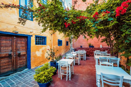 Street cafe in scenic picturesque streets of Chania venetian town with coloful old houses. Chania greek village in the morning. Chanica, Crete island, Greece