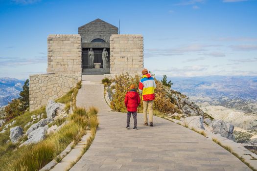 Dad and son travellers in mountain landscape at national park Lovcen, Montenegro. Travel to Montenegro with children concept.