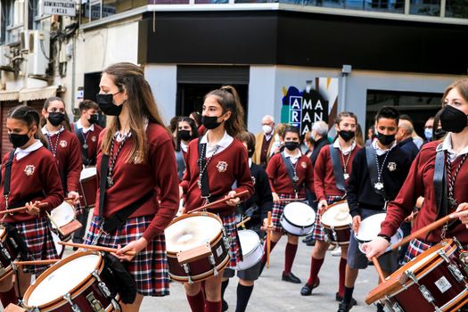 Elche, Alicante, Spain- April 10, 2022: Children Musicians in red uniform going out in procession in The Holy Week of Elche