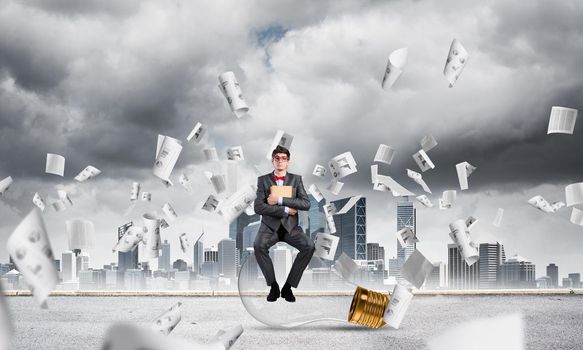 young businessman with a book. flying around papers in chaos