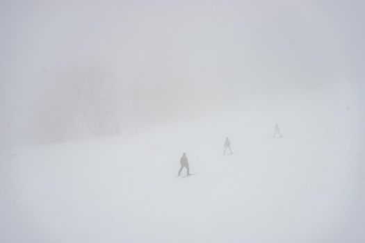 Skiers on the slopes in misty day in Bakuriani resort in Georgia
