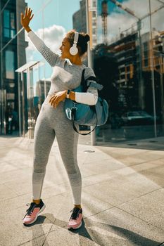 Full length shot of female athlete standing in the city ready for training. Sports