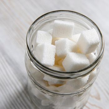 Glass jar with refined sugar in pieces