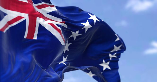 Close-up side view of the Cook Islands National flag waving in the wind. A clear sky in the background. Patriotism and pride. Selective focus