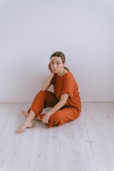 Portrait of young caucasian woman in red cloth. Dreamy