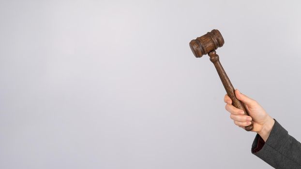Woman holding judge's gavel on white background
