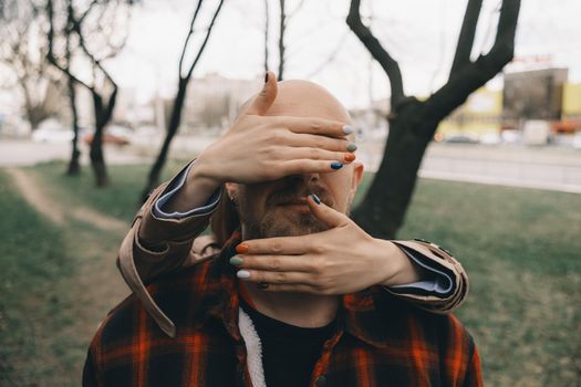 girl closes her lover's eyes from behind. hipster